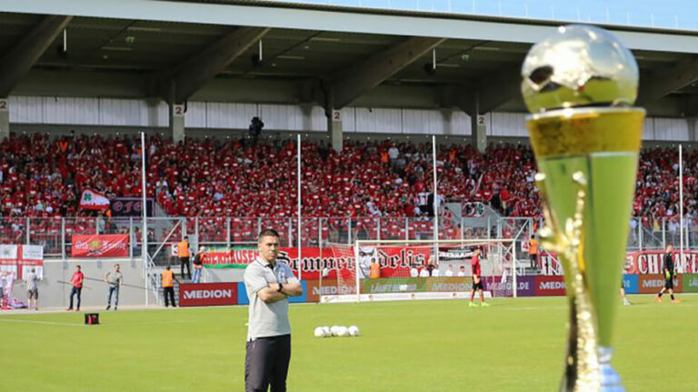 pokal mit spieler im hintergrund